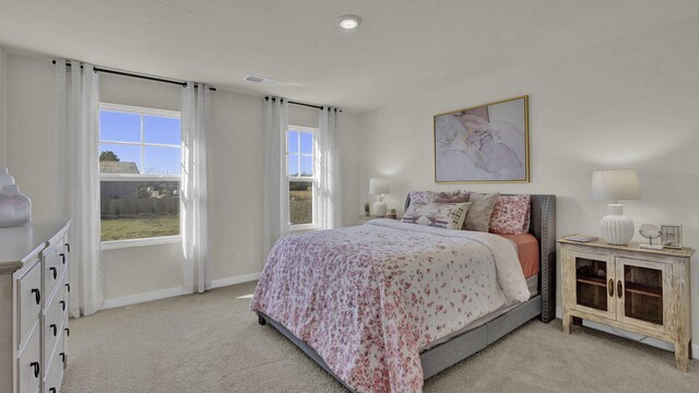 bedroom featuring visible vents, baseboards, and light colored carpet