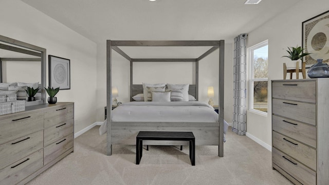 bedroom with baseboards and light colored carpet