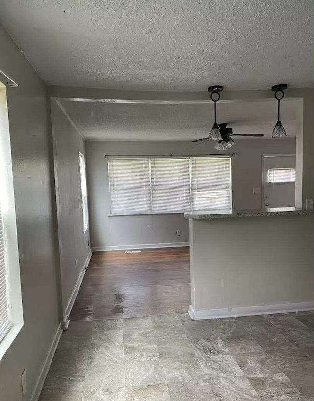 4922 Marylin Ln, Chattanooga, TN 37411 - empty room featuring healthy amount of natural light, a textured ceiling, ceiling fan, and baseboards
