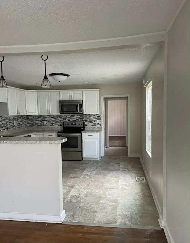 4922 Marylin Ln, Chattanooga, TN 37411 - kitchen featuring stainless steel appliances, white cabinetry, a textured ceiling, decorative backsplash, and pendant lighting