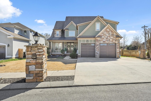 craftsman-style house with concrete driveway, stone siding, and an attached garage