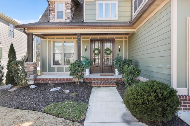 property entrance with a shingled roof and covered porch