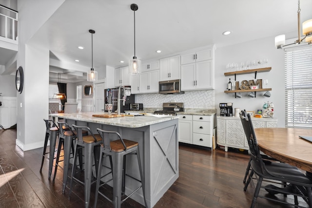 kitchen featuring white cabinetry, backsplash, dark wood-style floors, and stainless steel appliances