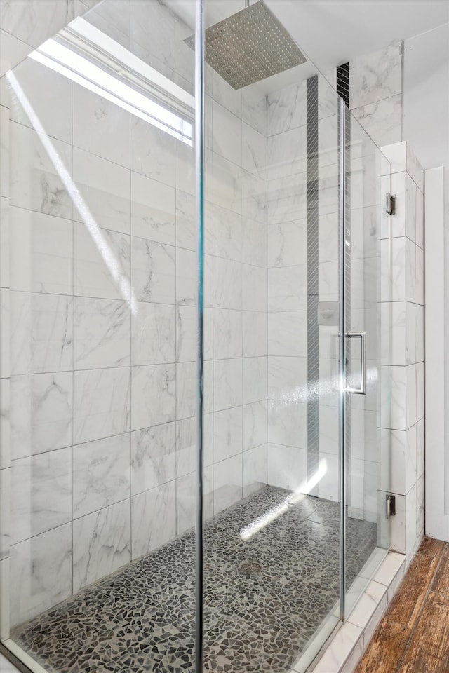 full bath featuring a shower stall and wood finished floors