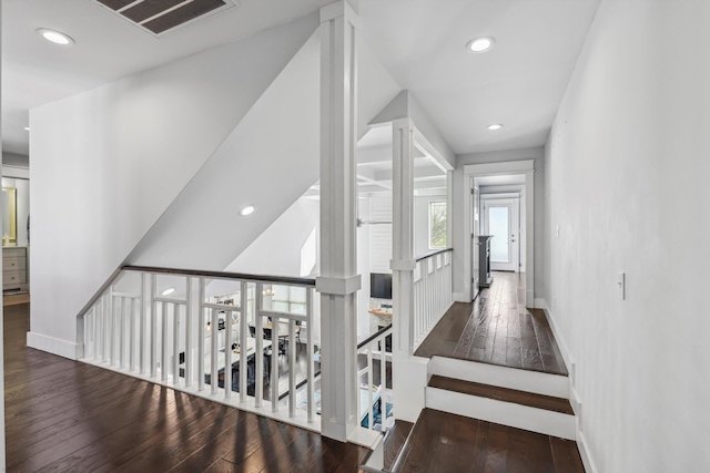 corridor featuring visible vents, recessed lighting, hardwood / wood-style floors, an upstairs landing, and baseboards