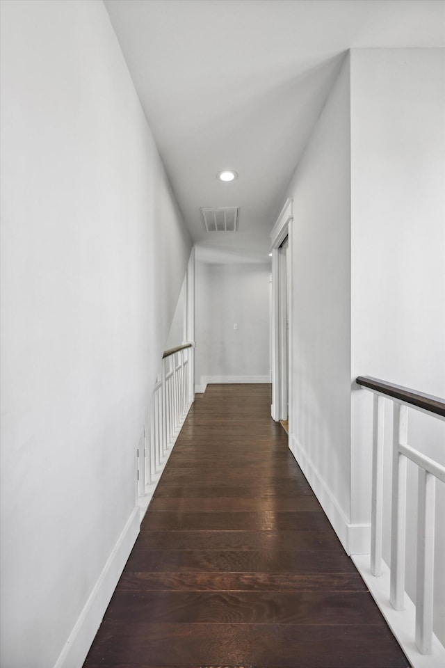 hallway featuring recessed lighting, visible vents, baseboards, and wood finished floors