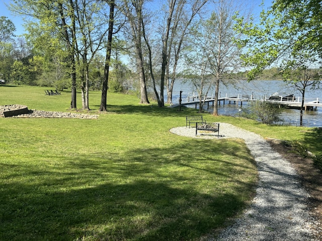 view of community with a water view, a yard, and a dock