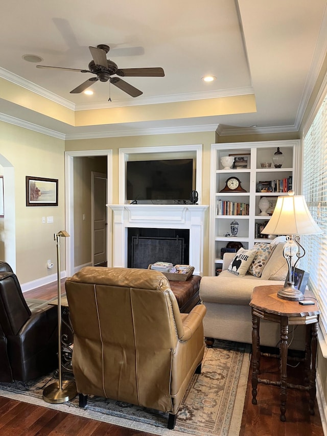1760 Holden Farm Pl, Ooltewah, TN 37363 - living room featuring a tray ceiling, a fireplace, wood finished floors, arched walkways, and a ceiling fan