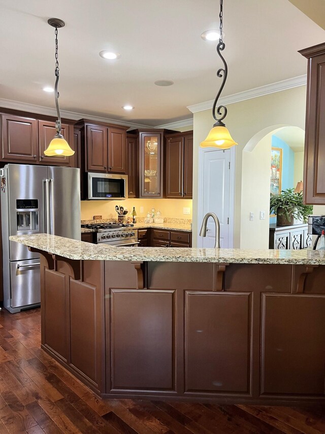 1760 Holden Farm Pl, Ooltewah, TN 37363 - kitchen featuring light stone counters, arched walkways, appliances with stainless steel finishes, a kitchen bar, and crown molding