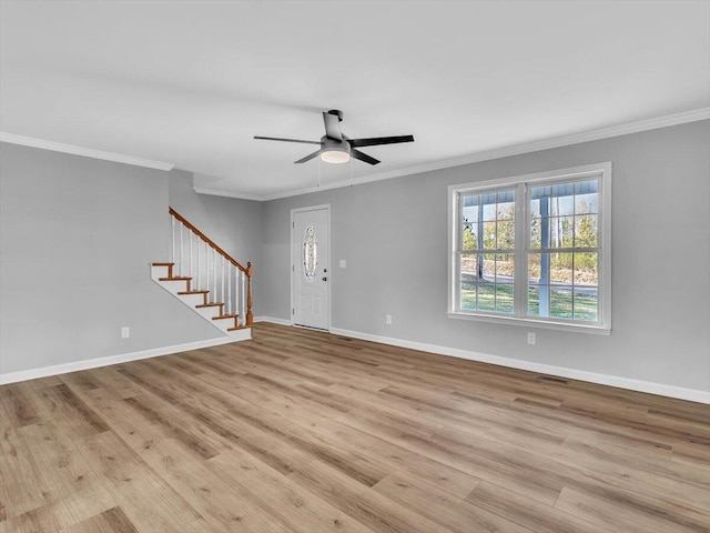 unfurnished living room with ornamental molding, baseboards, stairs, and wood finished floors