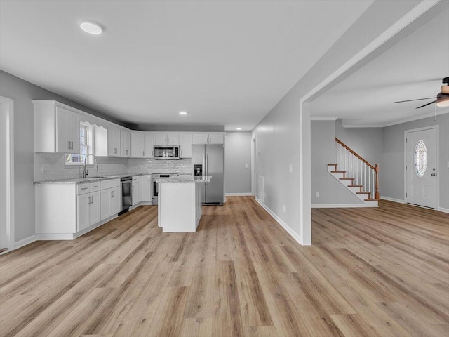 kitchen featuring open floor plan, appliances with stainless steel finishes, and decorative backsplash