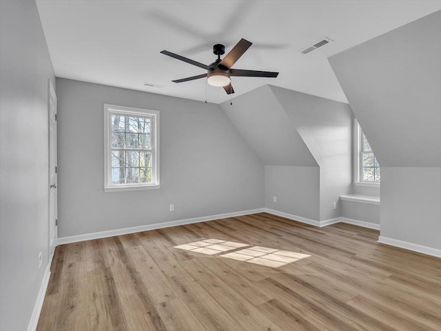 bonus room with vaulted ceiling, baseboards, ceiling fan, visible vents, and wood finished floors