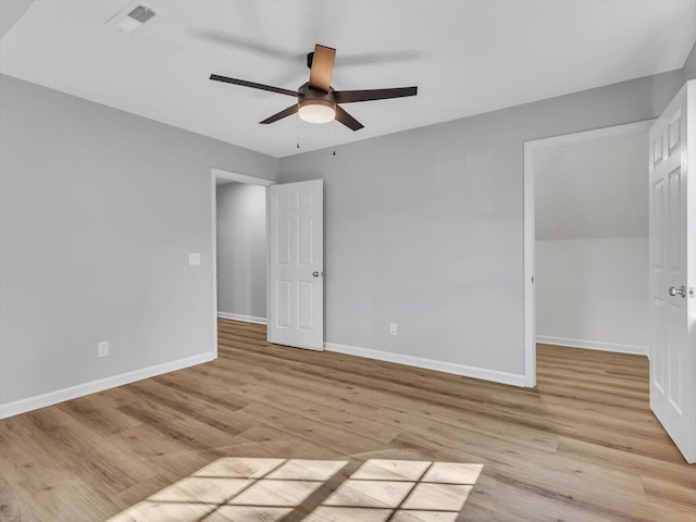 unfurnished bedroom featuring light wood finished floors, baseboards, visible vents, and a spacious closet