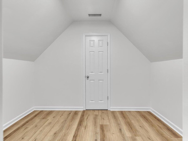 bonus room with light wood-style flooring, baseboards, and lofted ceiling