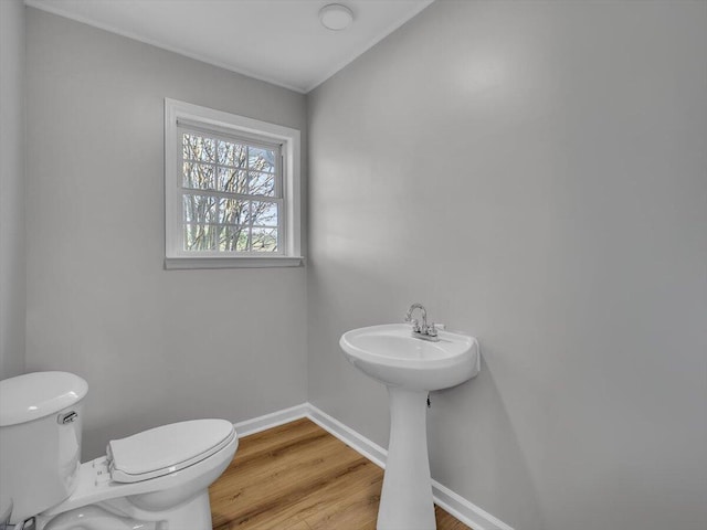 bathroom with baseboards, toilet, and wood finished floors