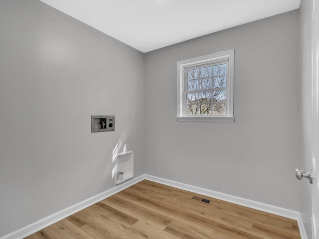 washroom featuring light wood-type flooring, laundry area, baseboards, visible vents, and hookup for a washing machine