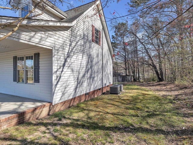 view of property exterior featuring a lawn, a shingled roof, central air condition unit, and crawl space