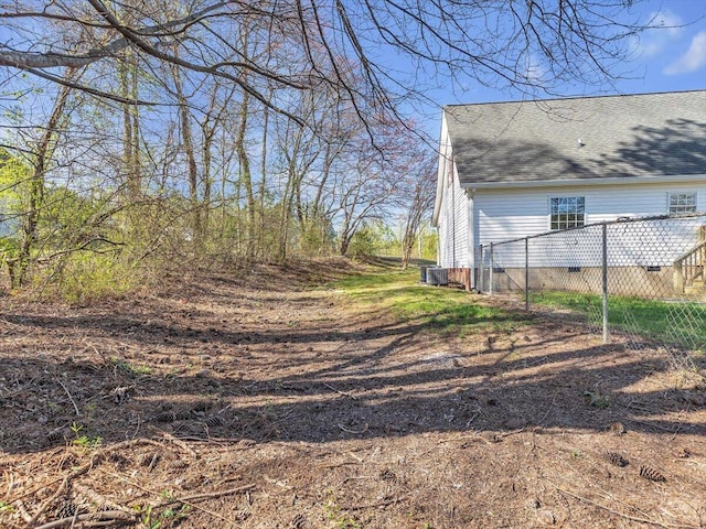 exterior space featuring central AC unit and fence