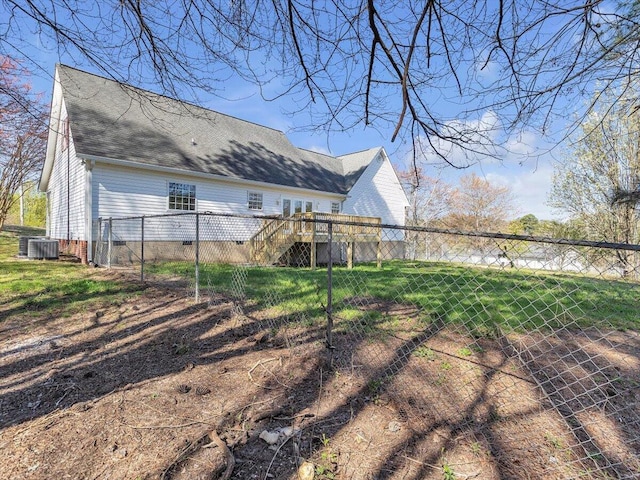 view of yard with fence, central AC, a wooden deck, and stairway
