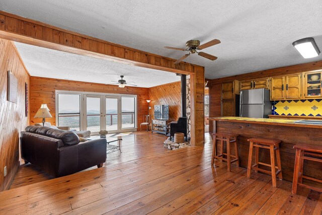 2345 County Rd 865, Gaylesville, AL 35973 - living area with light wood-type flooring, ceiling fan, a wood stove, and wood walls