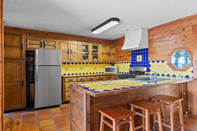 2345 County Rd 865, Gaylesville, AL 35973 - kitchen with tile countertops, brown cabinetry, a peninsula, a sink, and stainless steel appliances