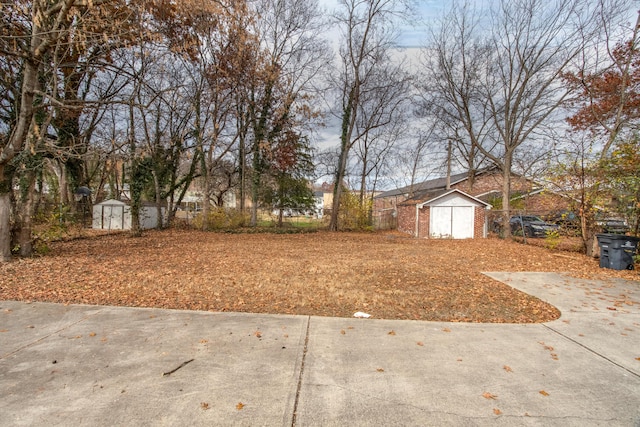 view of yard with an outdoor structure, a storage unit, and fence