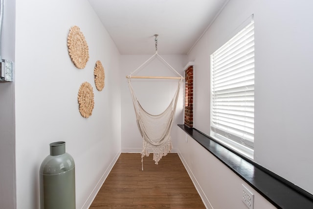 hallway with baseboards and wood finished floors