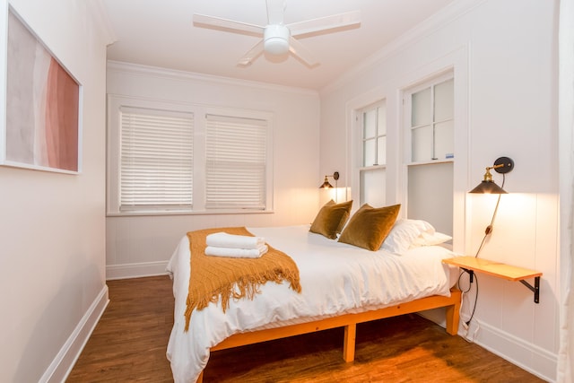 bedroom featuring baseboards, crown molding, wood finished floors, and a ceiling fan