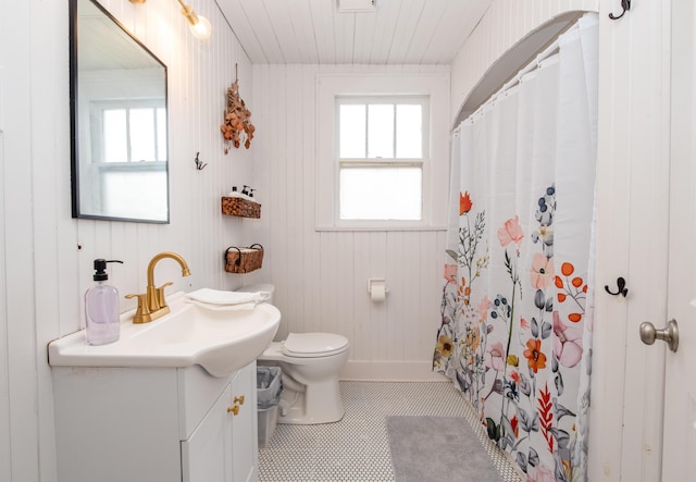 bathroom with toilet, a healthy amount of sunlight, vanity, and a shower with curtain