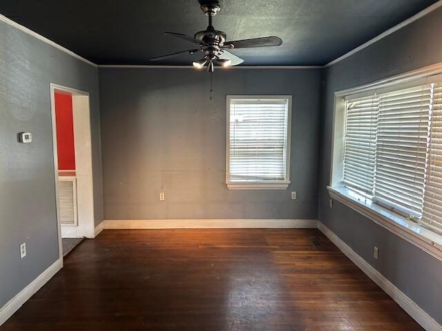 empty room with ceiling fan, baseboards, wood finished floors, and ornamental molding