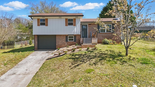 tri-level home featuring driveway, brick siding, fence, and a front yard