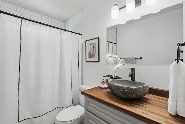 full bath with a shower with shower curtain, toilet, and vanity