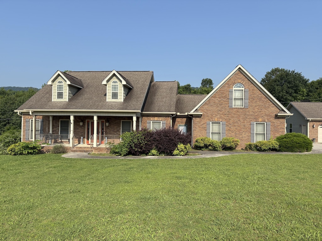104 Mountain View Dr, Flintstone, GA 30725 - cape cod house featuring brick siding, covered porch, a front lawn, and a shingled roof