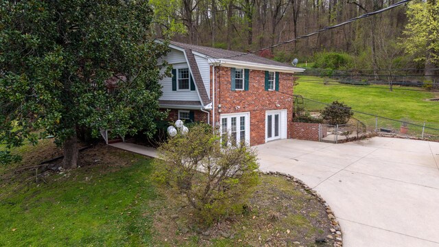 7004 Lystra Rd, Harrison, TN 37341 - view of front of home with brick siding, french doors, a patio area, driveway, and a view of trees