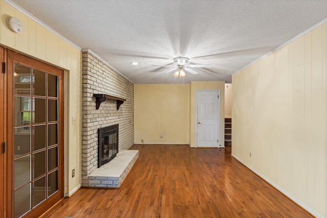 7004 Lystra Rd, Harrison, TN 37341 - unfurnished living room featuring ceiling fan, a textured ceiling, a brick fireplace, crown molding, and wood finished floors