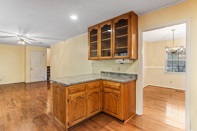 7004 Lystra Rd, Harrison, TN 37341 - kitchen featuring brown cabinetry, hardwood / wood-style floors, a peninsula, and glass insert cabinets