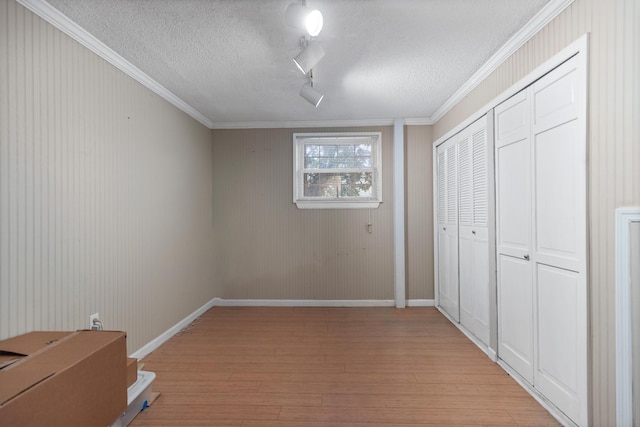 7004 Lystra Rd, Harrison, TN 37341 - unfurnished bedroom featuring light wood-style floors, crown molding, a closet, a textured ceiling, and rail lighting