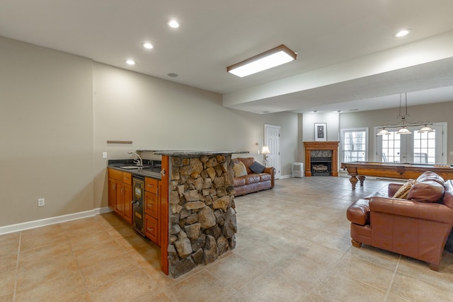 living area with wine cooler, baseboards, a fireplace, and recessed lighting