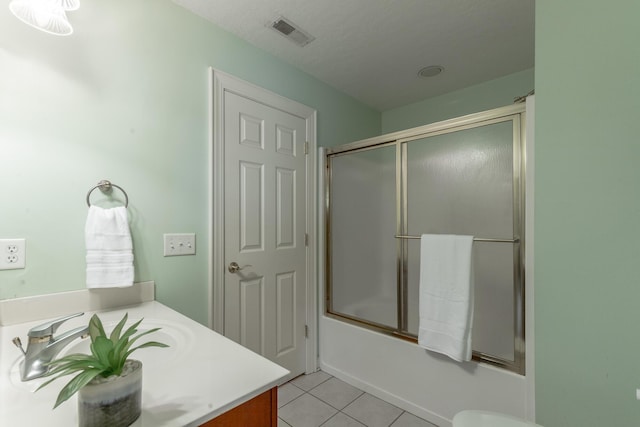 bathroom with vanity, bath / shower combo with glass door, tile patterned floors, and visible vents