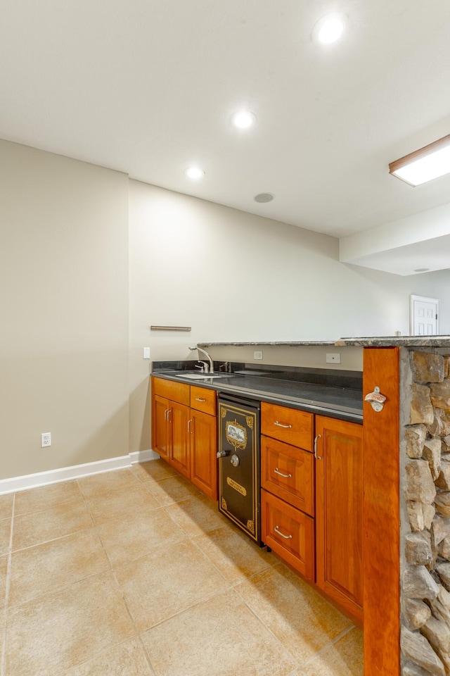 bar featuring baseboards, a sink, recessed lighting, and light tile patterned floors