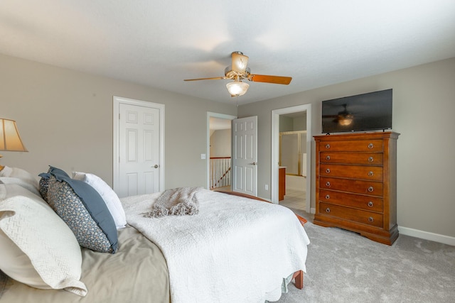 bedroom with ensuite bath, baseboards, a ceiling fan, and light carpet