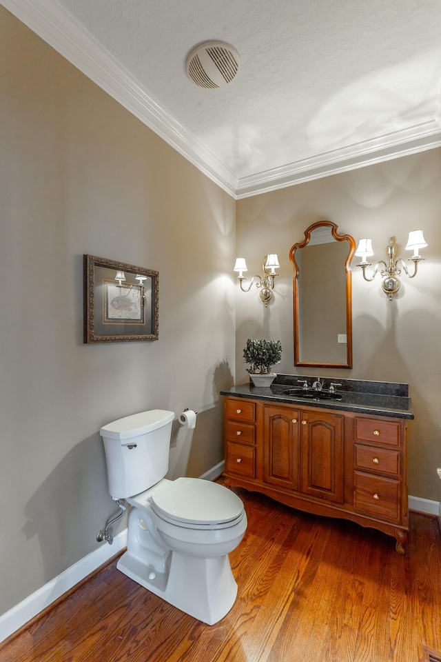 bathroom with wood finished floors, visible vents, baseboards, and ornamental molding