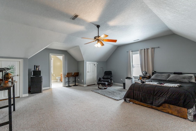 bedroom with ensuite bathroom, baseboards, lofted ceiling, carpet flooring, and visible vents