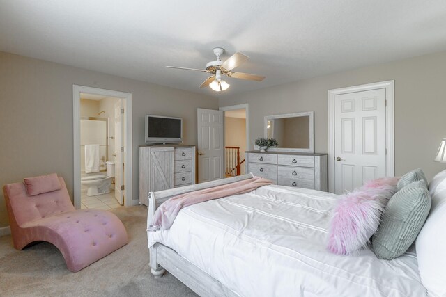 bedroom with light carpet, baseboards, ensuite bath, and ceiling fan