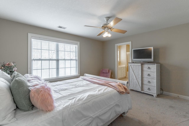bedroom featuring a ceiling fan, light carpet, baseboards, ensuite bath, and visible vents