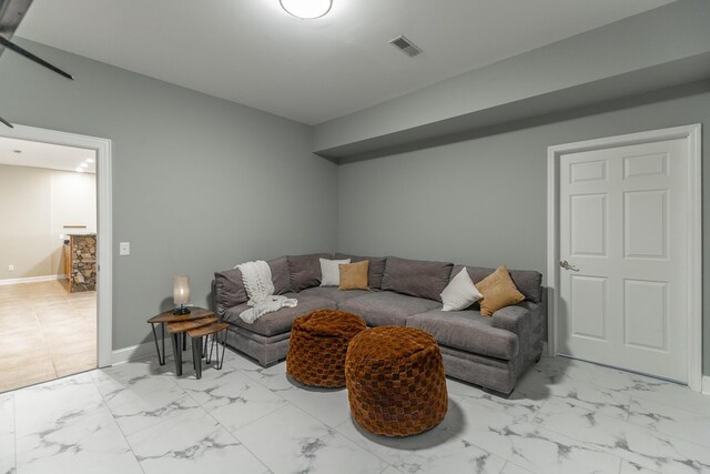 living area featuring baseboards, visible vents, and marble finish floor