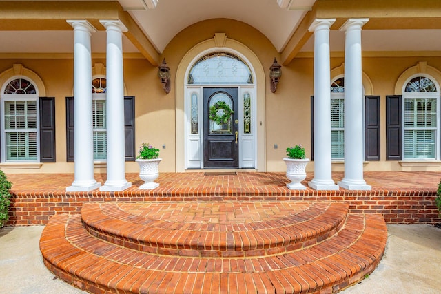 entrance to property featuring stucco siding and covered porch