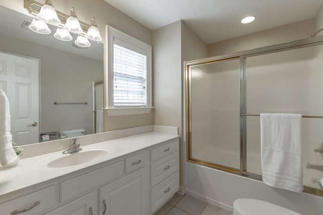 bathroom featuring bath / shower combo with glass door, toilet, vanity, and tile patterned floors