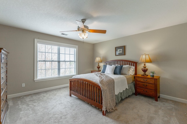 carpeted bedroom featuring visible vents, a ceiling fan, and baseboards