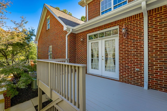 doorway to property with french doors, brick siding, and a deck